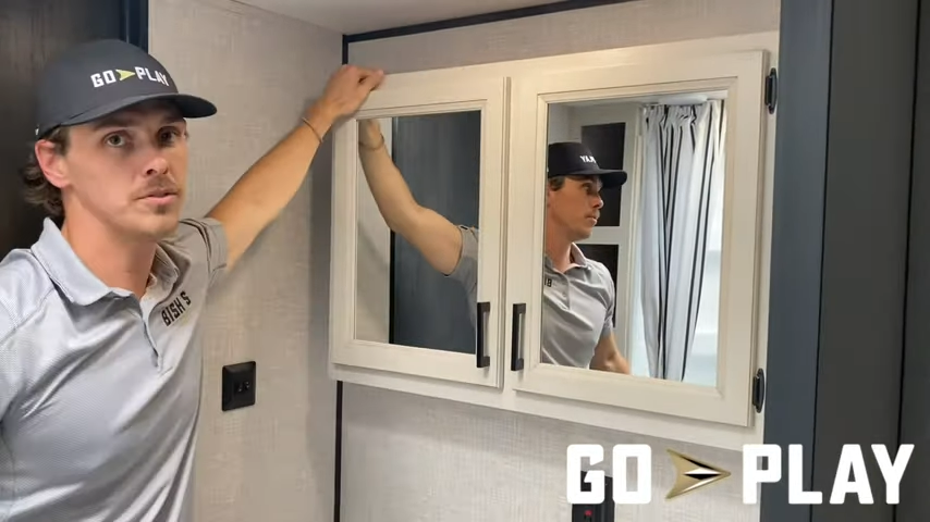 Jake, from Bish's RV, looking at mirror in Go Play RV bathroom