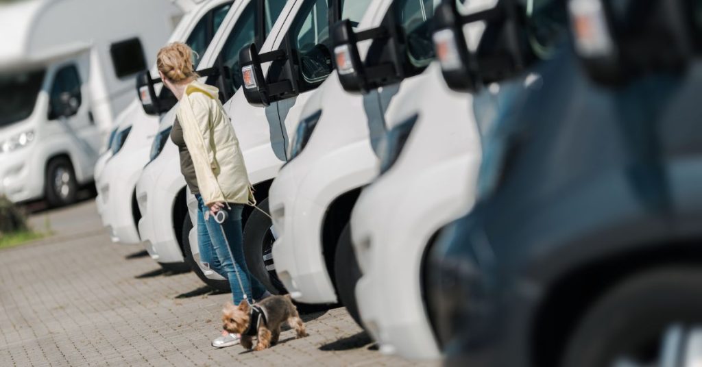 Lady with a dog in front of Class C line of Class C Motorhomes