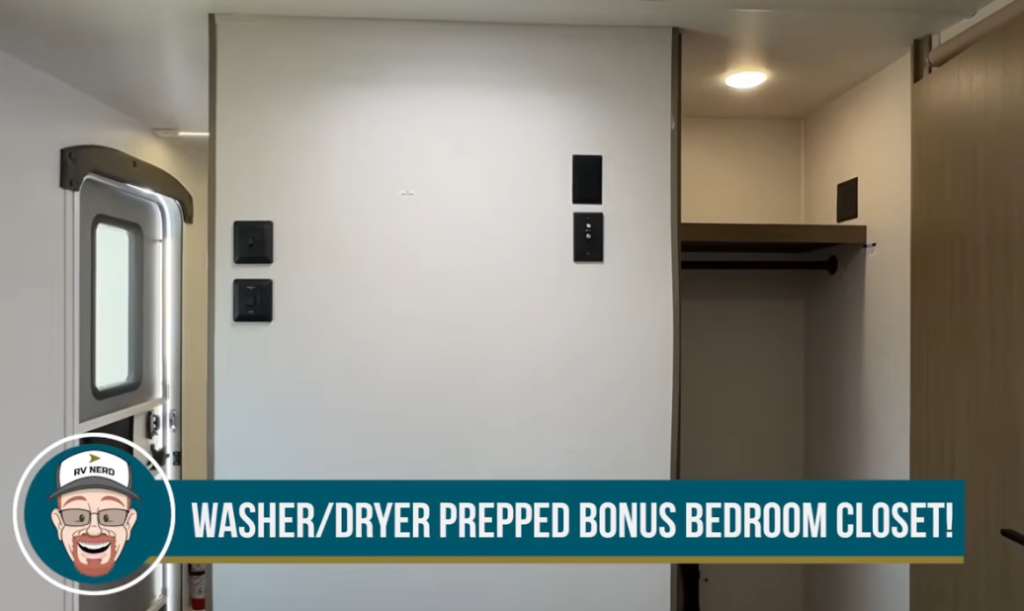 Interior view of an RV bedroom closet area prepped for a washer and dryer, featuring a recessed closet space with a hanging rod, electrical hookups, and a nearby entry door; a banner at the bottom reads “WASHER/DRYER PREPPED BONUS BEDROOM CLOSET!” with RV Nerd branding.