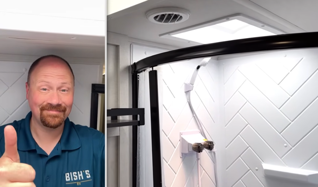 Split-screen image showing a smiling man in a blue Bish's RV polo giving a thumbs-up on the left side inside an RV shower, with the right side displaying a spacious RV shower stall featuring white herringbone-patterned walls, a skylight, and curved black trim.