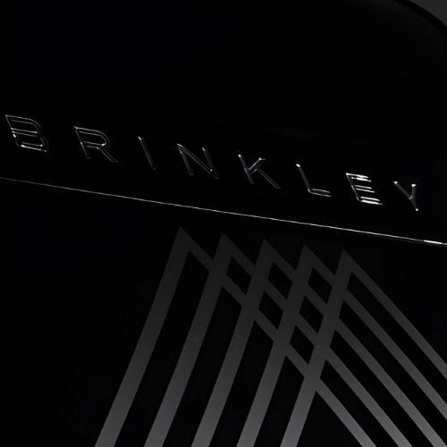Close-up view of the front cap of a Brinkley RV, featuring a sleek black finish with the BRINKLEY name in bold silver lettering above the brand’s distinctive geometric mountain-inspired logo.