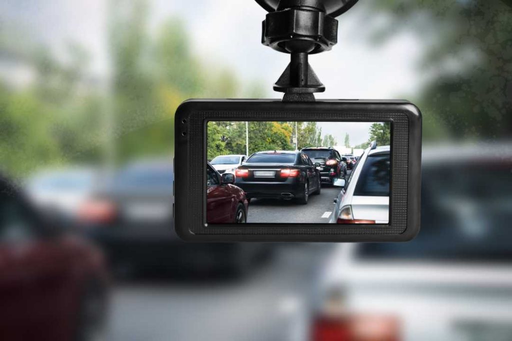 Dash cam recording cars in heavy traffic, mounted on windshield, capturing clear road view for driving safety and accident protection.