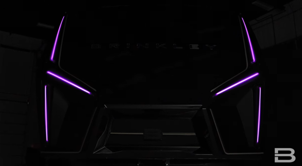 Front cap of a Brinkley RV illuminated with purple LED accent lights, showcasing modern design and customizable exterior lighting features.