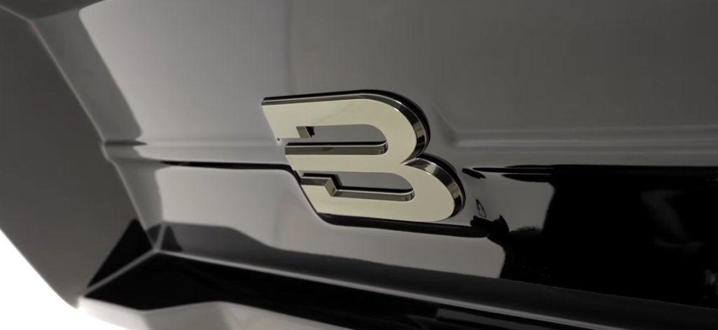 Close-up of a chrome Brinkley RV logo “B” on a glossy black front cap, highlighting luxury design and premium RV branding.