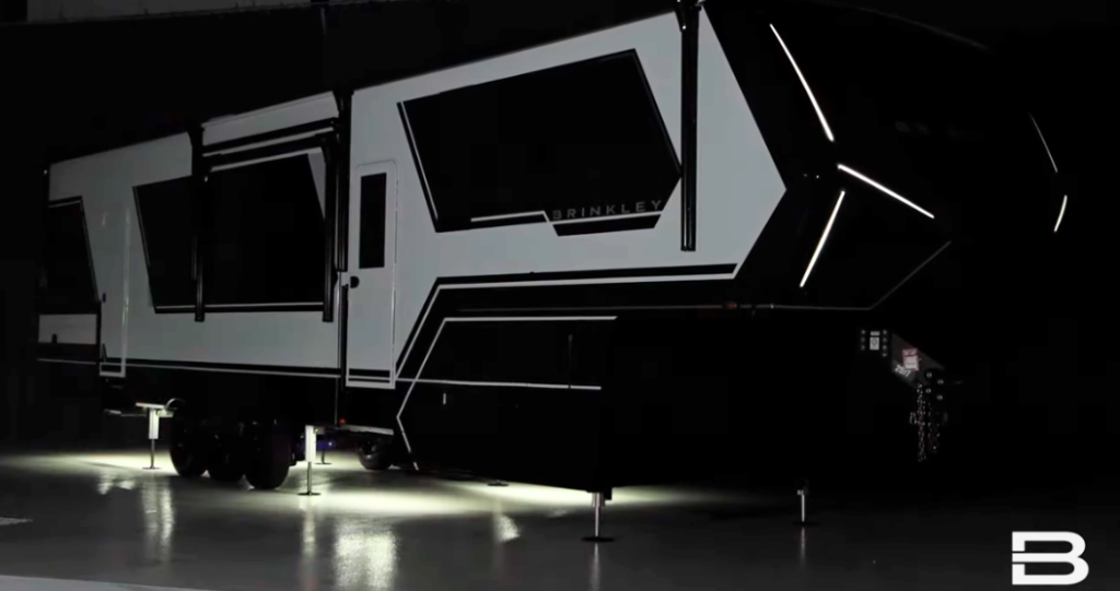 2026 Brinkley fifth wheel RV illuminated at night with LED accent lighting and under-glow, showcasing modern luxury exterior design.