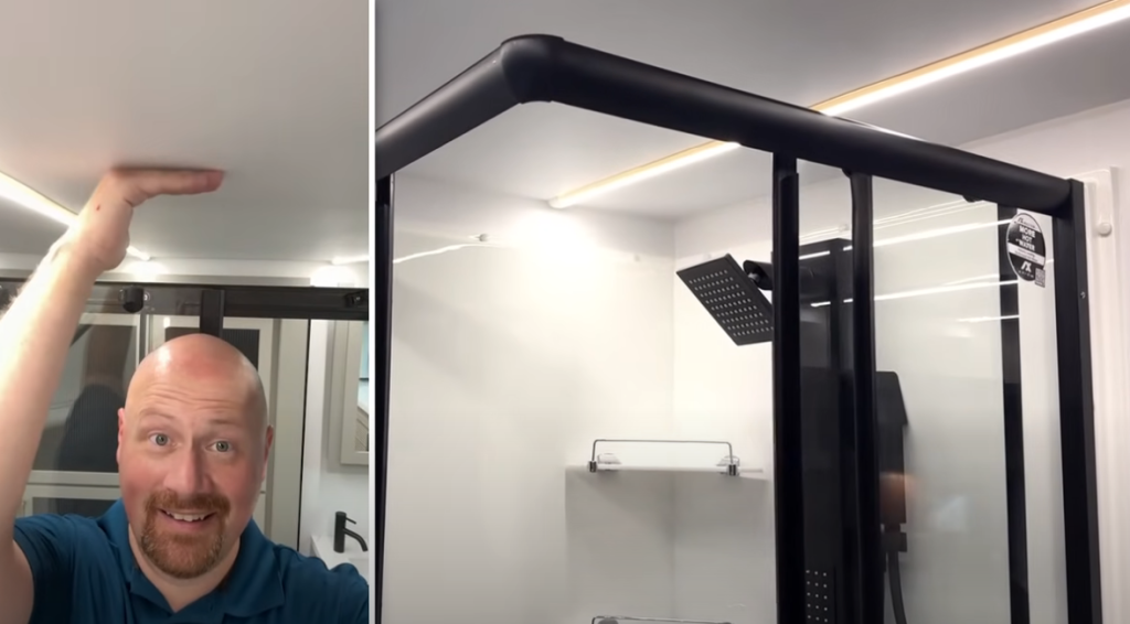 Bathroom inside the 2026 Axiom Imperium I3800 showcasing extra ceiling height and a modern black-framed glass shower with rainfall showerhead, emphasizing spacious design and premium construction.