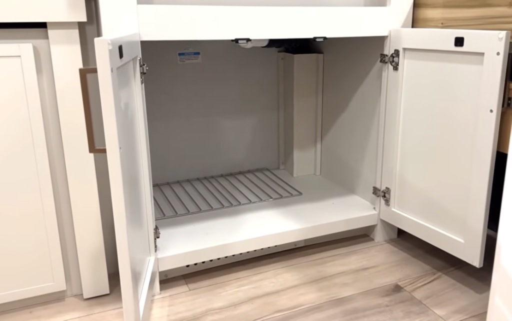 Brinkley Model Ix 20X under-sink cabinet with wire shelf and plumbing access, designed for optional dishwasher installation or extra RV kitchen storage.