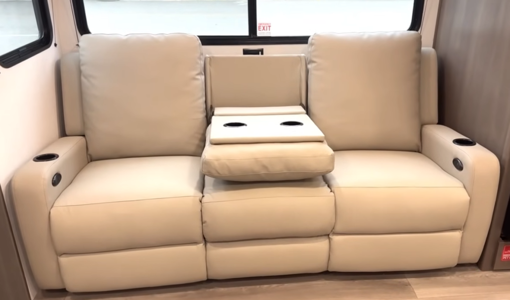 Grand Design Transcend Xplor RV interior with tan reclining theater seating, center console cup holders, and large rear windows.