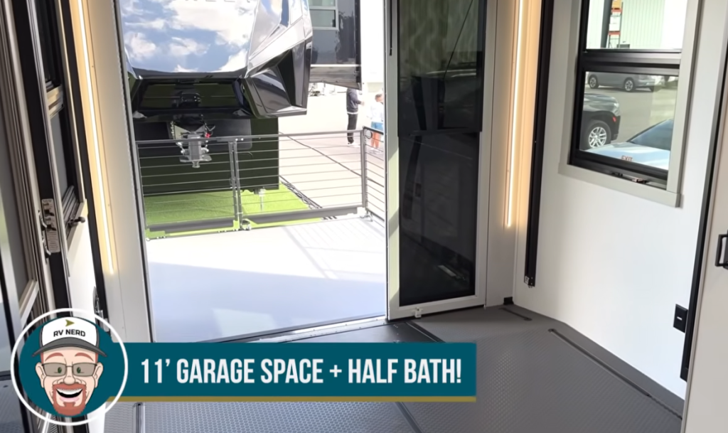 Brinkley Model G Series RV garage showcasing 11-foot cargo space with patio ramp door open, durable flooring, and bright windows, designed for flexible use as a lounge, office, or toy hauler area with half bath.