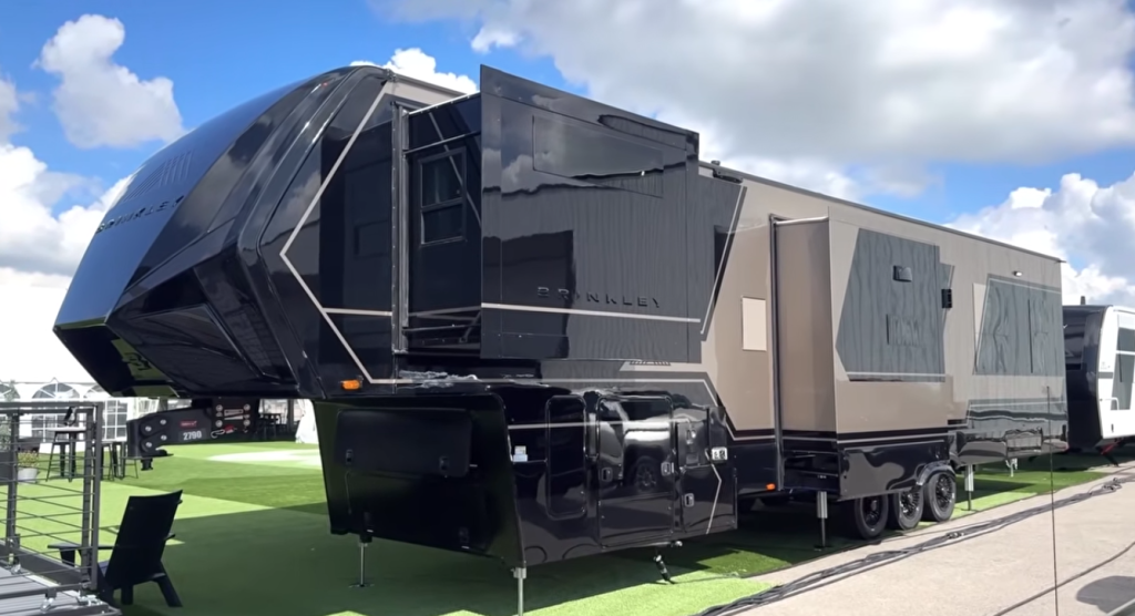 Brinkley Model G Series luxury fifth wheel exterior in black and bronze finish with multiple slide-outs extended, showcasing bold automotive styling, aerodynamic front cap, and premium construction.