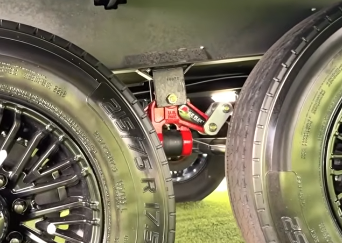 Brinkley Model G Series RV suspension close-up featuring heavy-duty Dexter equalizer system with red HD components and premium tires for smoother towing and improved road handling.