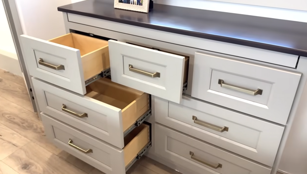 Brinkley Model G Series RV bedroom dresser with multiple deep storage drawers, gold hardware, and soft LED accent lighting, offering elegant organization and residential-style design.