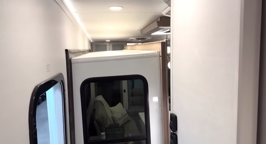 Alliance Paradigm fifth wheel interior shown with slides closed, highlighting accessibility to living space and hallway during travel mode.