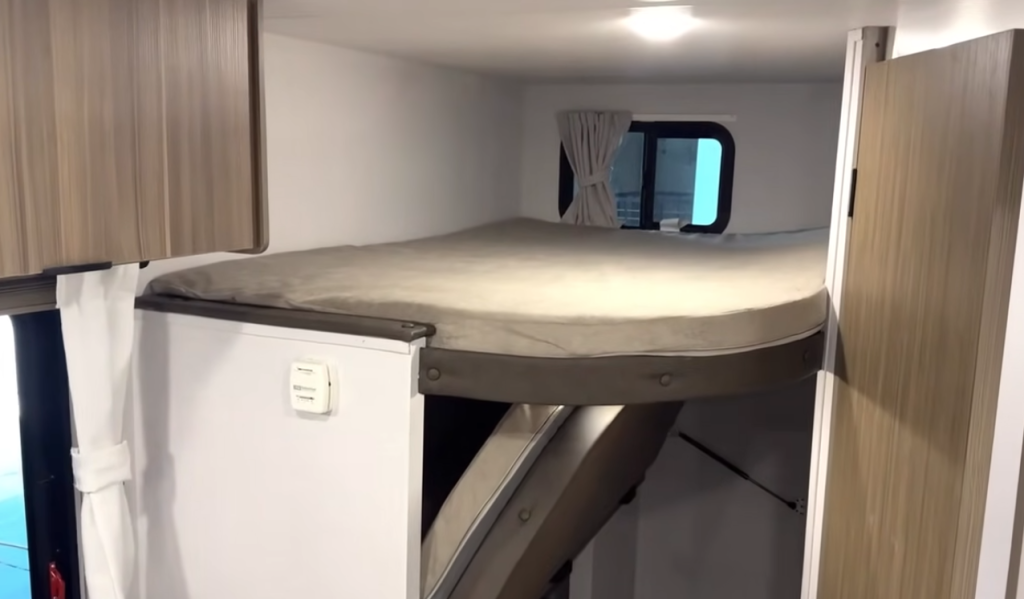 Forest River Wildwood FSX RV interior showing double-over-double rear bunks with windows and privacy curtains for family sleeping space.