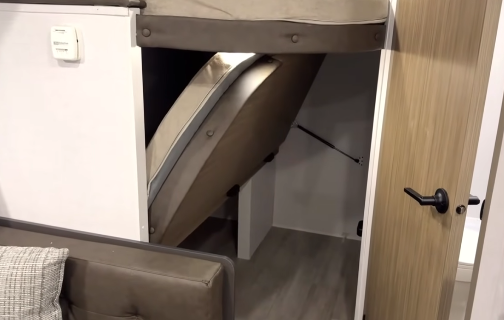 Forest River Wildwood FSX RV bunk area with lift-up lower bunk for expanded storage or gear space beneath the sleeping area.