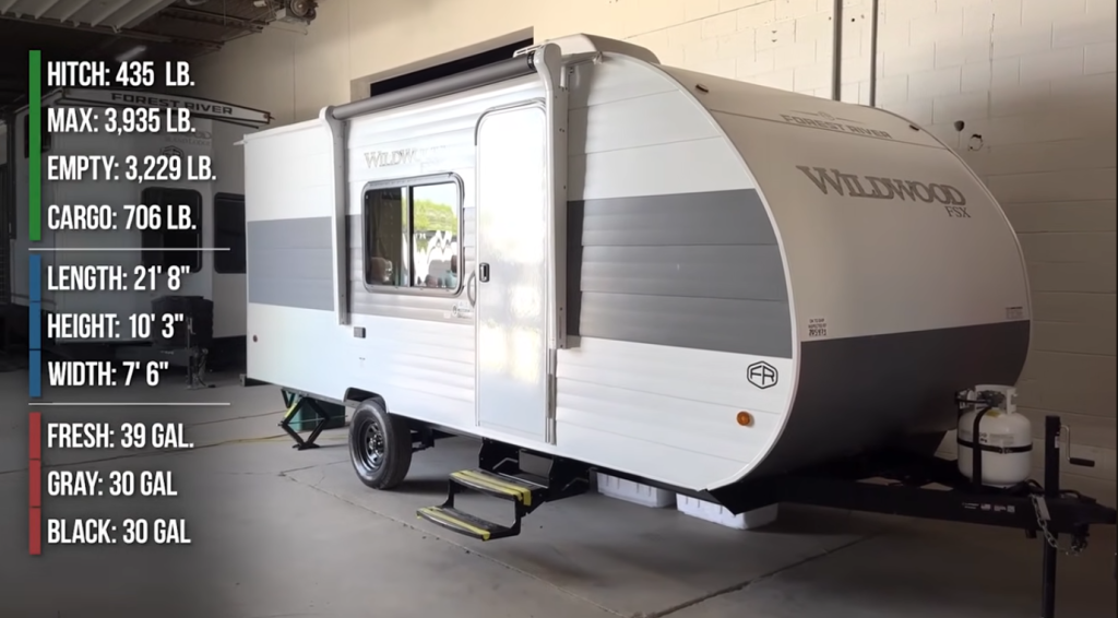 Forest River Wildwood FSX 21-foot travel trailer with aluminum siding, single axle, front propane setup, and weight and tank capacity specs displayed.