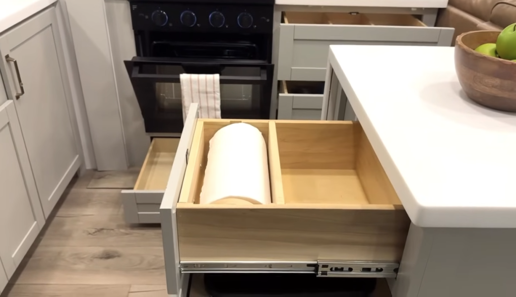 Brinkley Model Z kitchen drawer system featuring a built-in paper towel holder and deep pull-out storage compartments beside the oven, showcasing thoughtful and organized RV kitchen design.