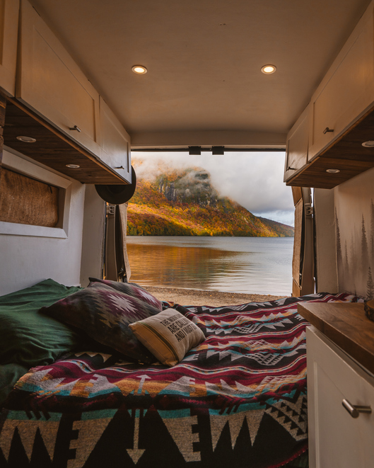 Camper Van Interior Vanlife Doors Open Autumn Scene Lake Camping Colorful Fall Foliage. Bed Blanket Digital Nomad Pillows Custom Build Beautiful View