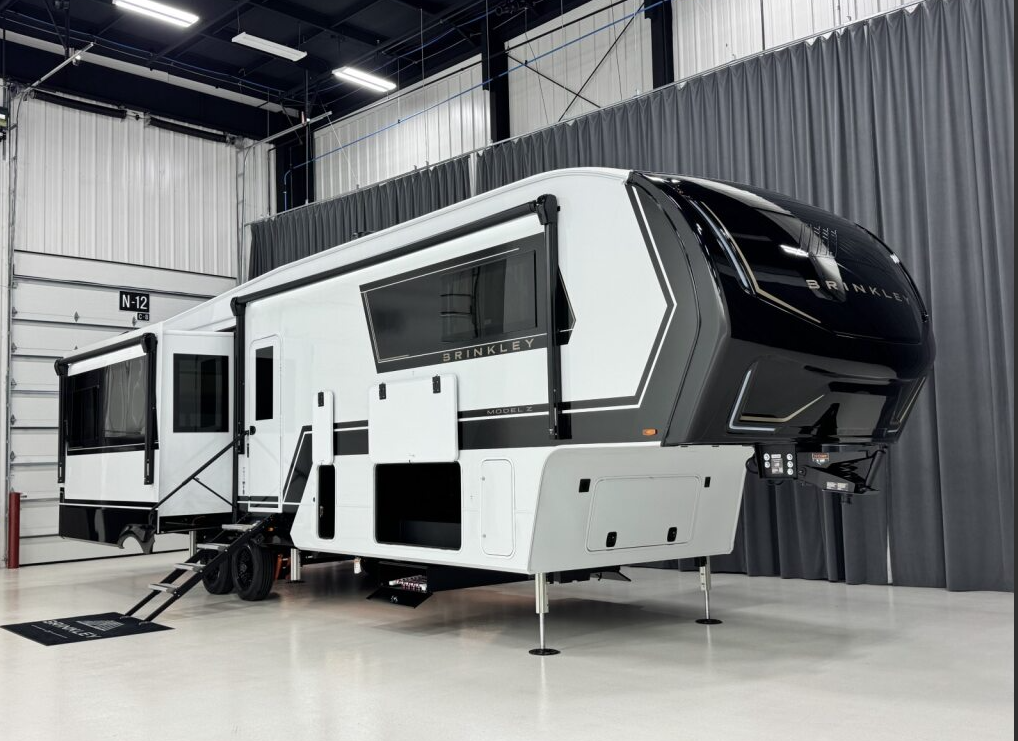 Exterior of the Brinkley Model Z 3600 fifth wheel showcasing its modern front cap design, dual slide-outs, pass-through storage, and sleek black-and-white paint scheme.