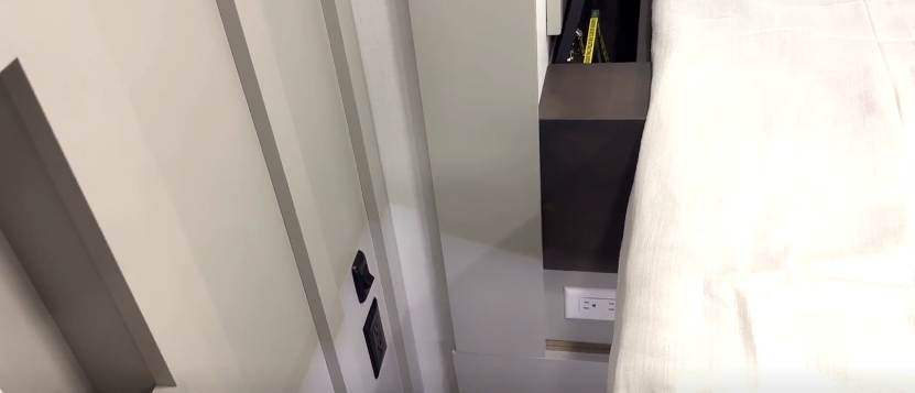 Close-up view of the Brinkley Model Z 3600 bedroom showing bedside outlets, storage cubby, and modern cabinetry with integrated power access for convenient device charging.