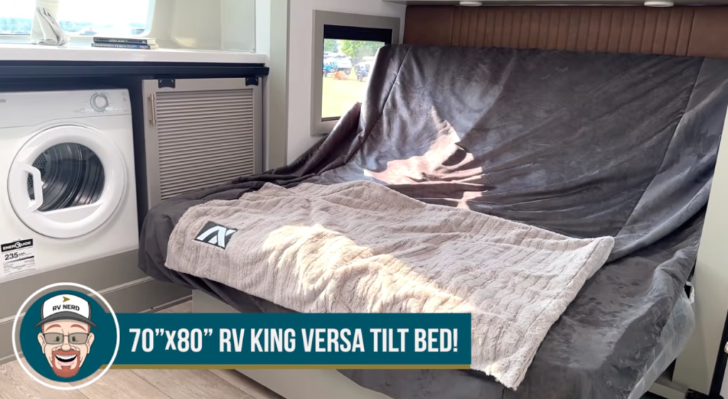 Bedroom of the 2026 Axiom Vendetta 4250 fifth wheel showcasing a 70”x80” RV king Versa tilt bed beside a built-in washer-dryer combo and modern cabinetry, offering luxury comfort and functionality.