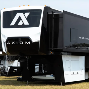 Front exterior of the 2026 Axiom Vendetta fifth wheel toy hauler showcasing its bold black-and-white design, aerodynamic front cap with Axiom logo, high-gloss steel-laminated sidewalls, and spacious pass-through storage area, representing luxury construction and modern RV engineering.
