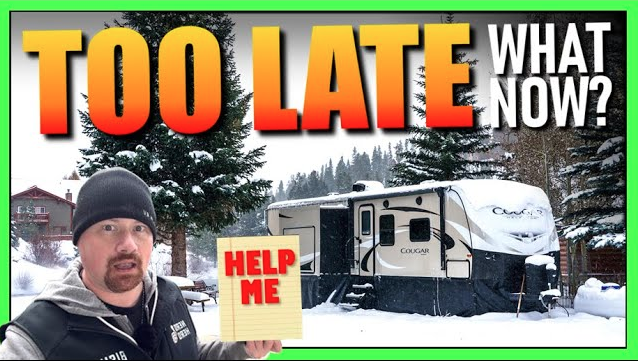 Winter RV scene showing a snow-covered Cougar travel trailer and RV expert holding a “Help Me” sign with bold text reading “Too Late, What Now?” — illustrating frozen RV problems and cold weather prep urgency.