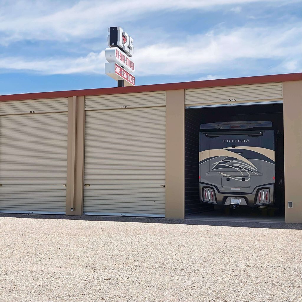 Indoor RV storage unit with large roll-up doors at a 125 RV, Boat & Storage facility, showing a luxury Entegra motorhome parked securely inside a private bay.