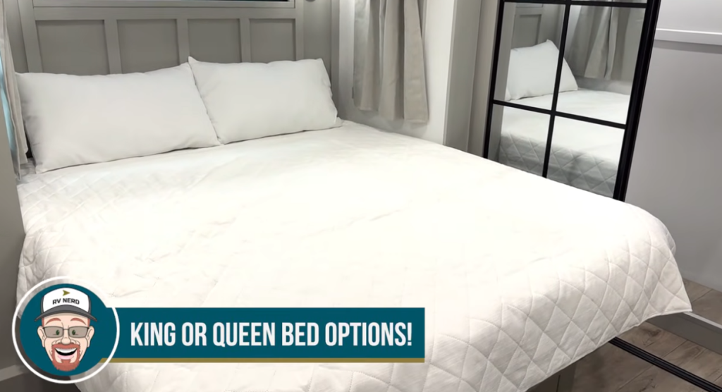 Spacious RV bedroom featuring a king or queen bed option, white bedding, large mirrored wardrobe, and modern interior design in a Brinkley fifth wheel.