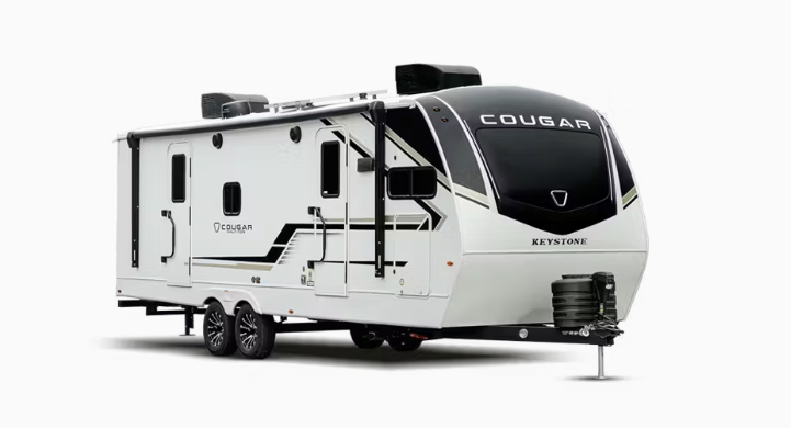 Keystone Cougar travel trailer exterior showing dual axles, front aerodynamic cap, large windows, slide-out, and modern white-and-black graphics.
