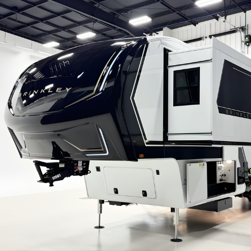 Showcasing the Brinkley Model Z 3200 luxury fifth wheel RV highlights its glossy black front cap with prominent Brinkley branding, extending slide-outs, and a well-lit showroom.