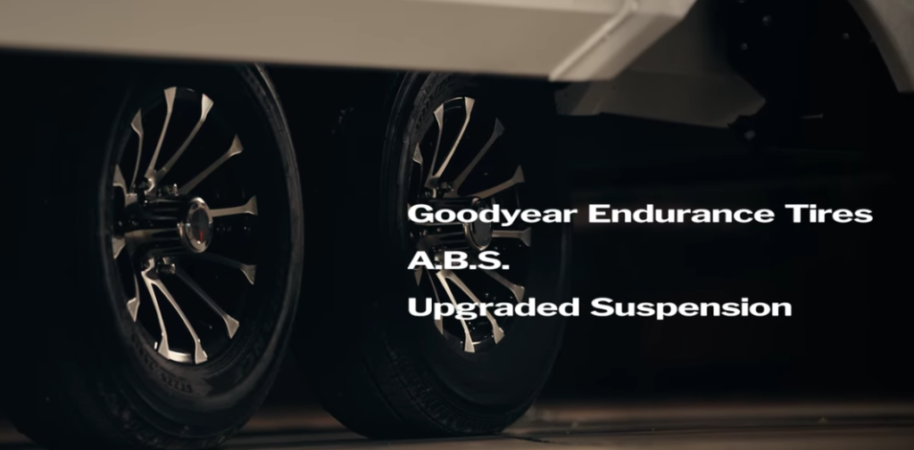 Close-up of dual-axle RV wheels featuring Goodyear Endurance tires, upgraded suspension, and ABS braking system for improved towing stability and safety.