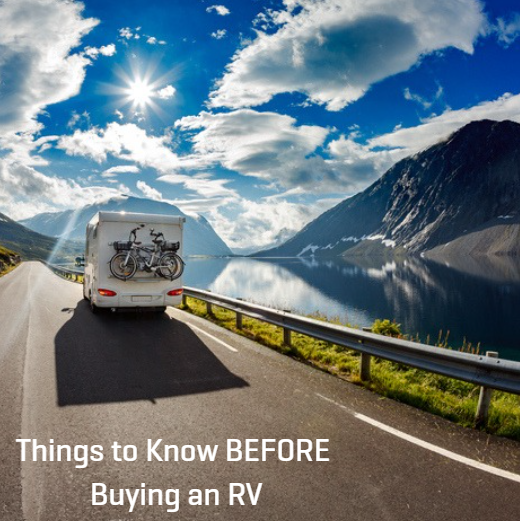 RV driving along a scenic mountain road beside a lake, representing things to know before buying an RV