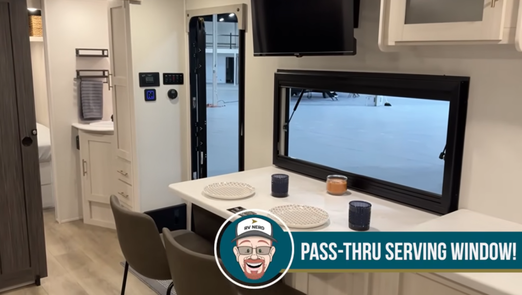 RV dinette with pass-through serving window, countertop seating, and view into the kitchen area