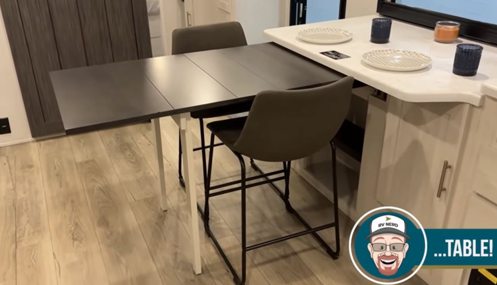 RV dinette with expandable table and bar seating, showing flexible dining and workspace layout