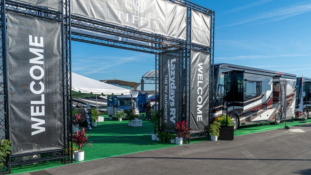 RV show entrance with welcome banners and luxury motorhomes on display