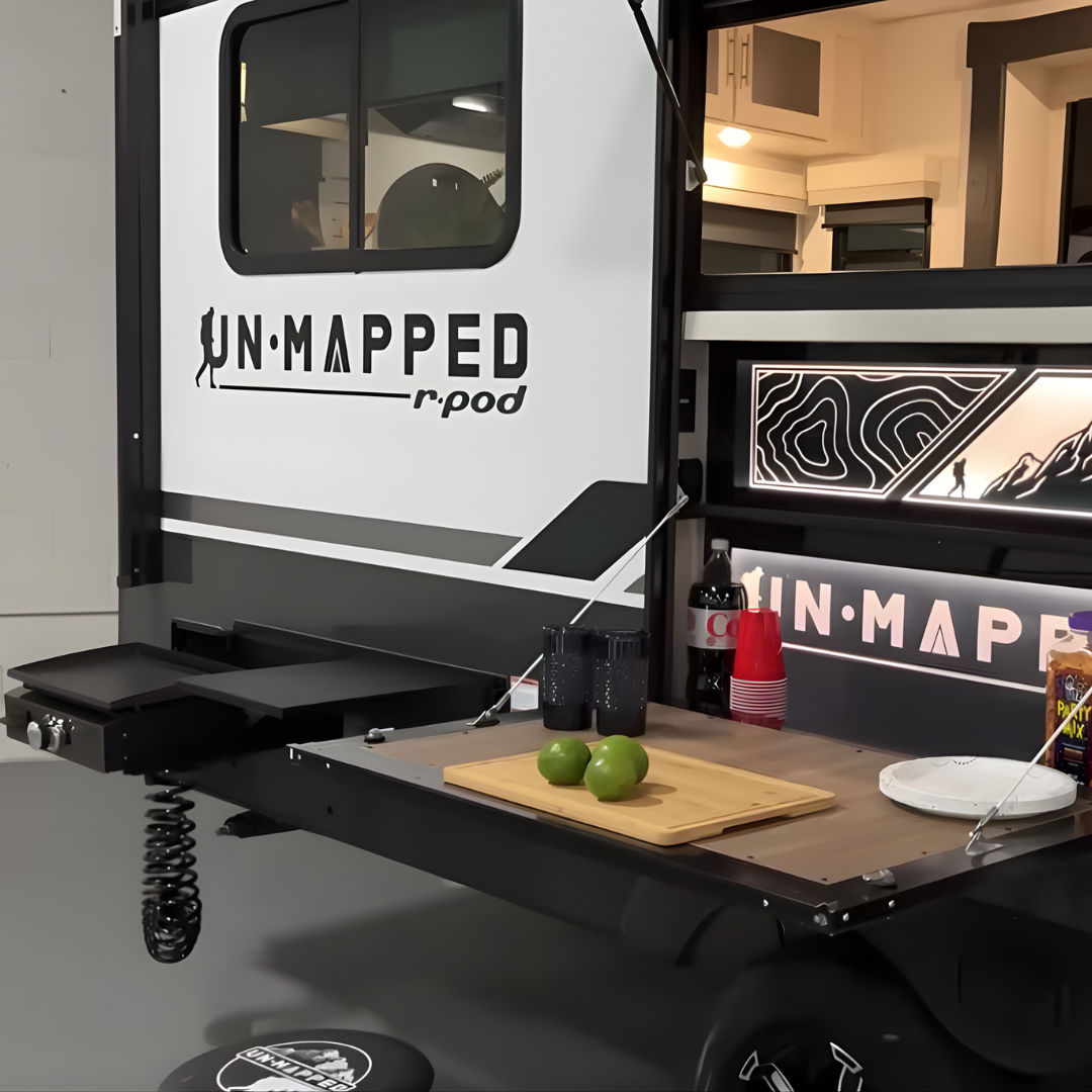 Unmapped R-Pod travel trailer rear outdoor kitchen with fold-down prep table and serving window