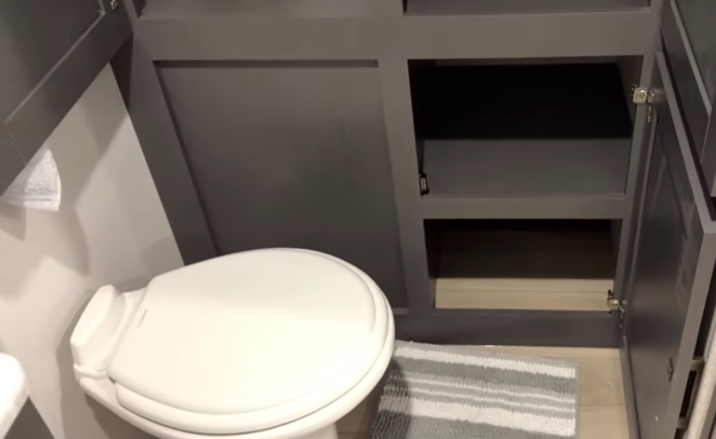 RV bathroom with foot-flush toilet and built-in cabinet storage