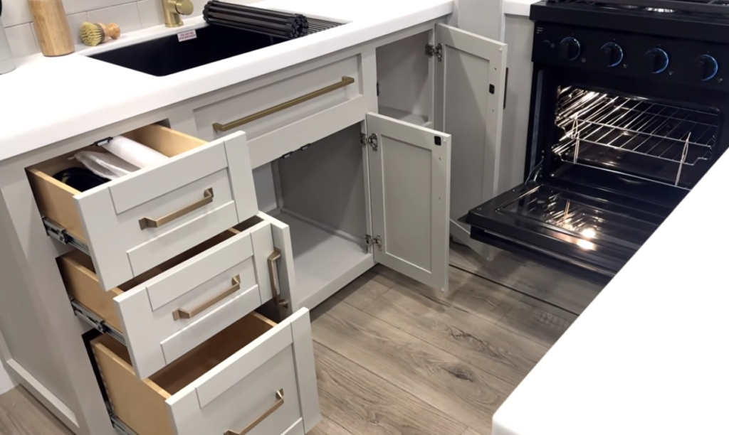 RV kitchen with open drawers, cabinet storage, and oven