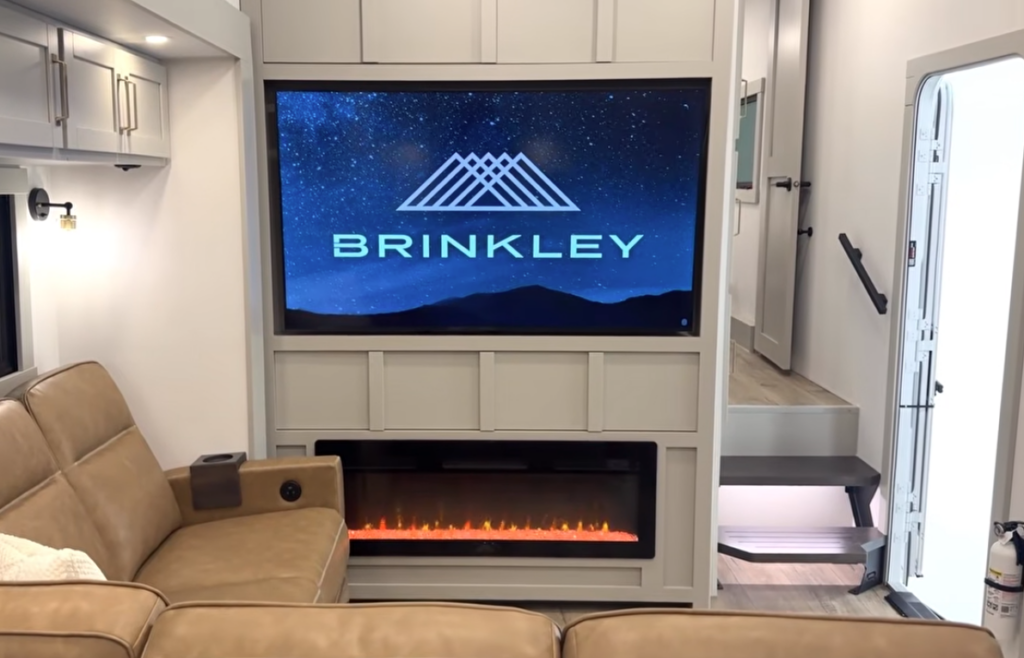 RV entertainment center with TV and electric fireplace inside Brinkley fifth wheel