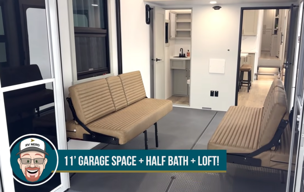 Toy hauler RV garage with opposing fold-down sofas and half bath access