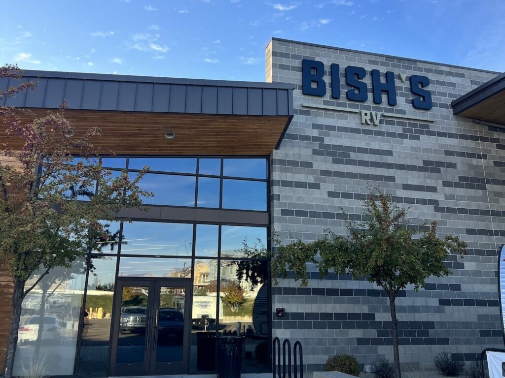 Exterior of Bish’s RV dealership building with signage, glass entrance, and modern facade.