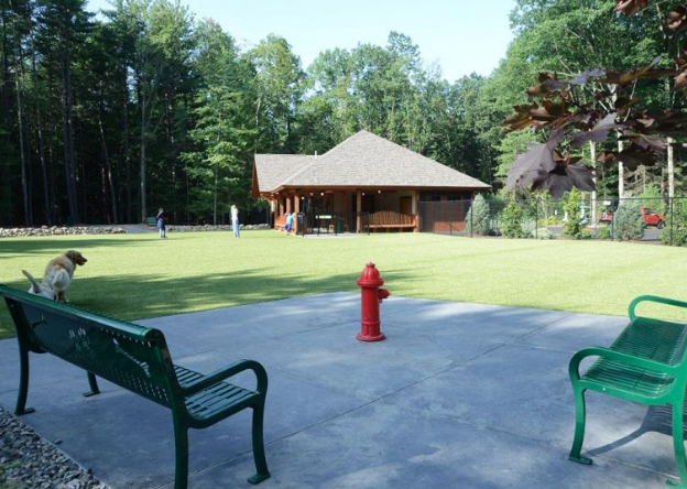 Pet-friendly dog park and play area at RV park with fenced lawn and pavilion