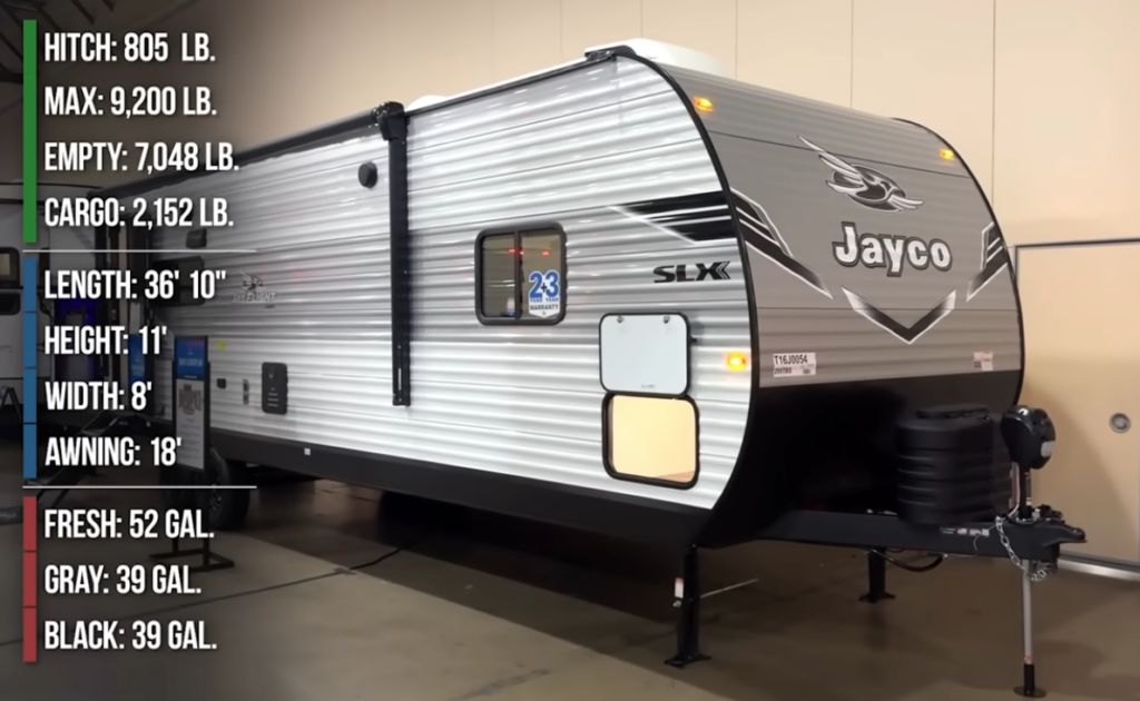 Jayco Jay Flight SLX travel trailer on display with specifications listed including weight, length, tank capacities, and awning size.