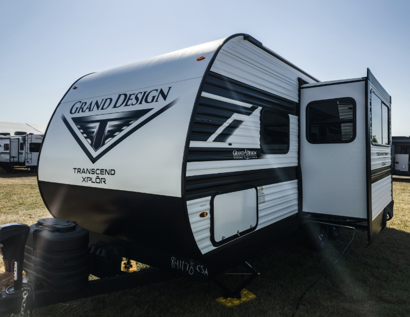 Grand Design Transcend Xplor travel trailer with slide-out extended displayed on an RV lot.