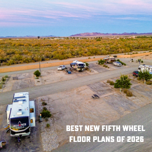 Aerial view of RV campground with multiple trailers and vehicles parked in a desert landscape at sunset.