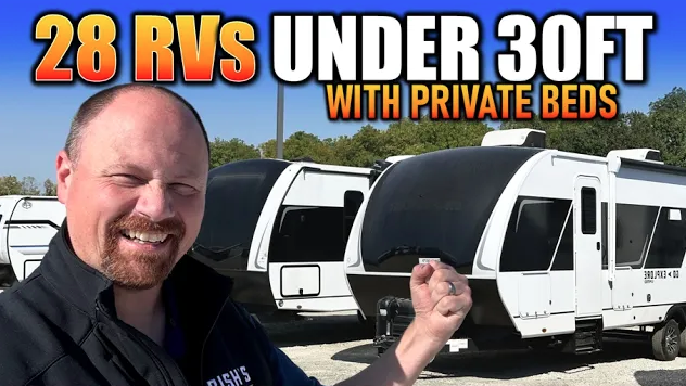 Man standing in front of travel trailers pointing toward them, with text overlay reading “28 RVs under 30ft with private beds.
