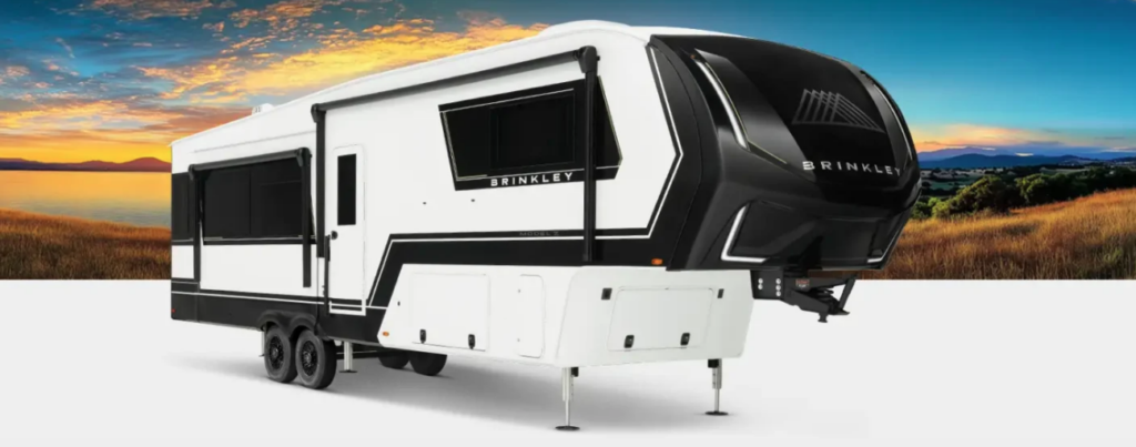 Brinkley fifth wheel RV with slide-out extended, shown on a clean backdrop with a scenic sunset landscape behind it.