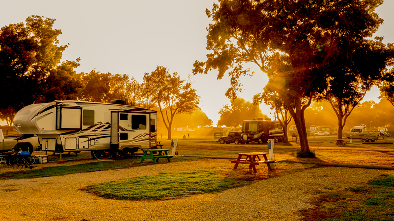 Sunsets on Rv park with motorhomes and vehicles parked at campsites