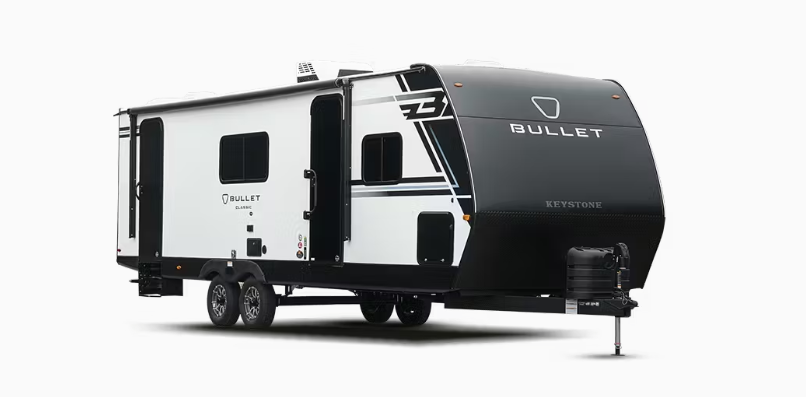Keystone Bullet travel trailer with white and black exterior, dual axles, slide-out, and front hitch shown on a white background